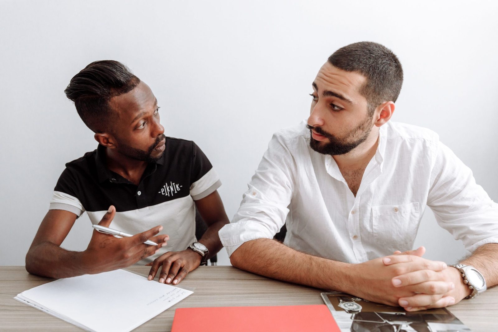 Two diverse men engage in a serious office discussion, emphasizing collaboration and teamwork.